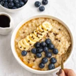 A bowl of Creamy Barley Porridge topped with blueberries and cinnamon.
