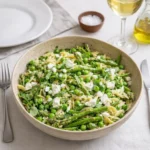 Fresh Spring Orzo Pasta Salad Recipe in a white ceramic bowl on a wooden table.