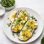 Smashed 7-Minute Eggs On Toast on a plate with fresh herbs